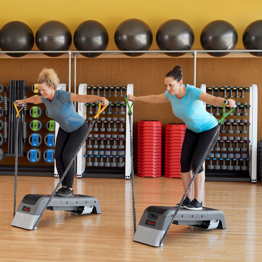 Two women exercising on Life Fitness Studio Decks with Resistance Tubes in a gym