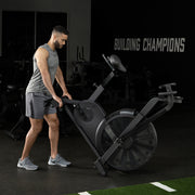 Exerciser moving HD Air Bike on front wheels at gym
