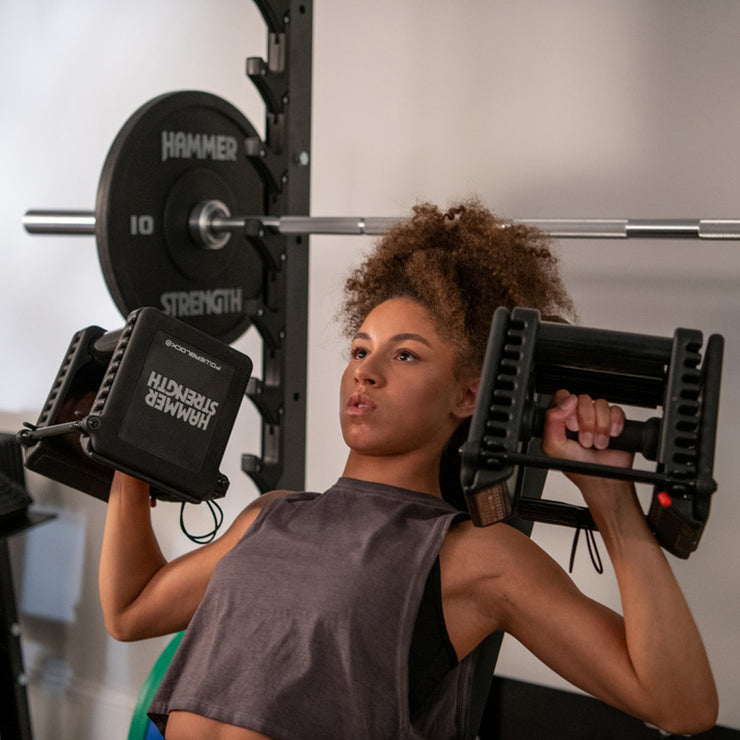 Female shoulder pressing with Hammer Strength dumbbells, low weight