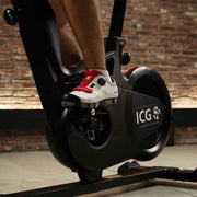Closeup of pedals and flywheel on IC5 indoor cycle, man pedaling