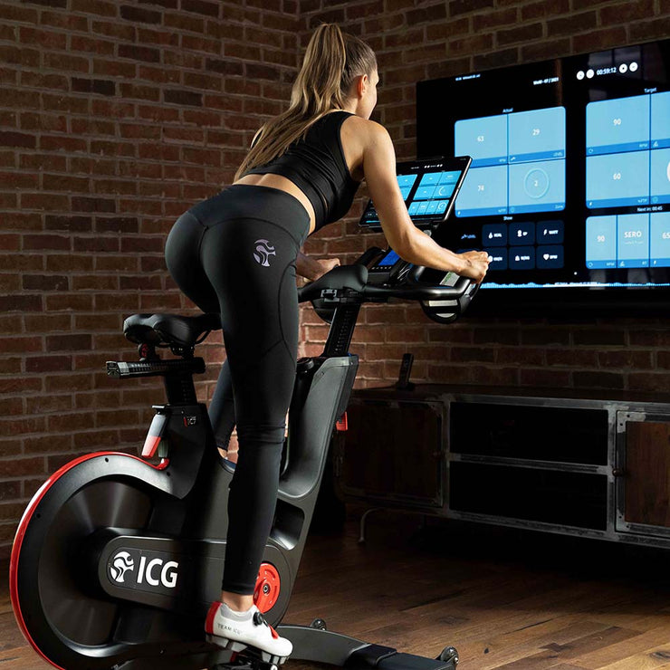 Female riding IC7 Indoor Cycle and screencasting workout app to TV