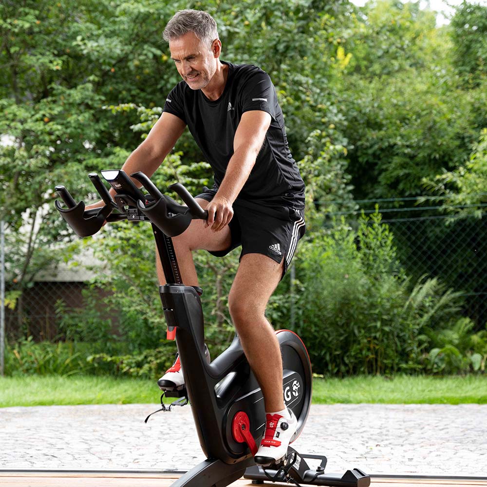 Man riding IC7 exercise bike outside