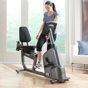 Female stepping into Life Fitness RS1 Recumbent LifeCycle bike, front angle